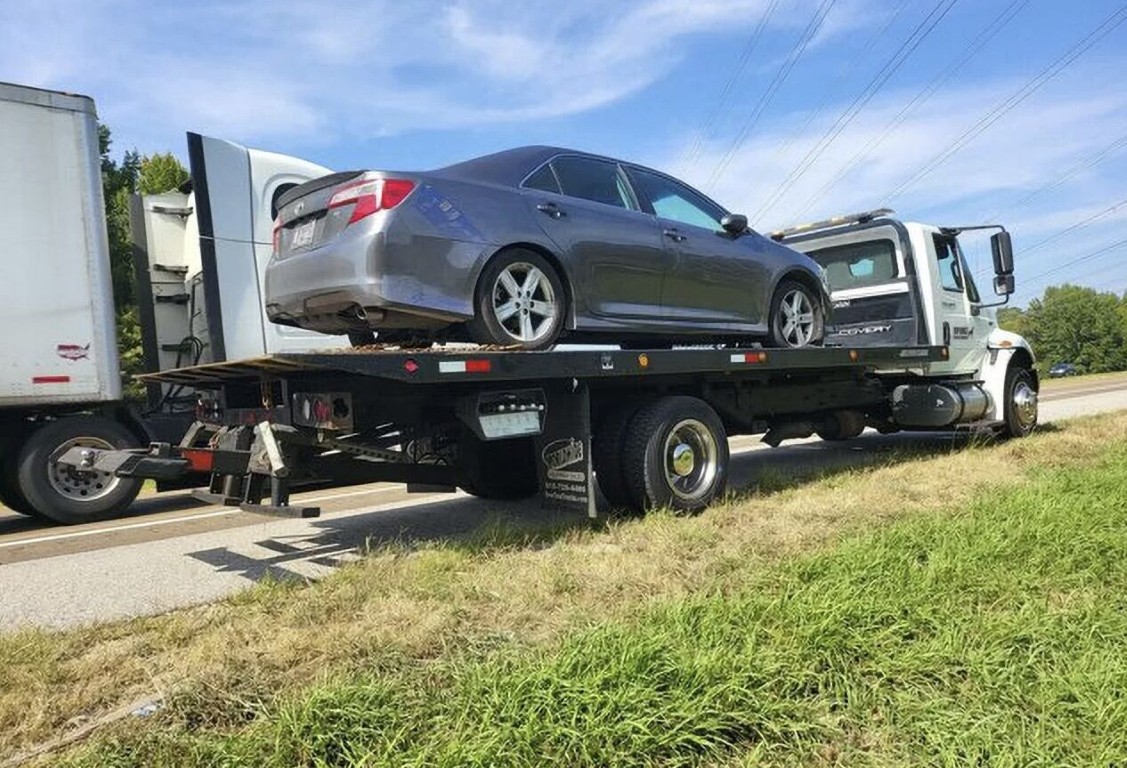 Tow truck operator responding to a car lockout service call on a highway